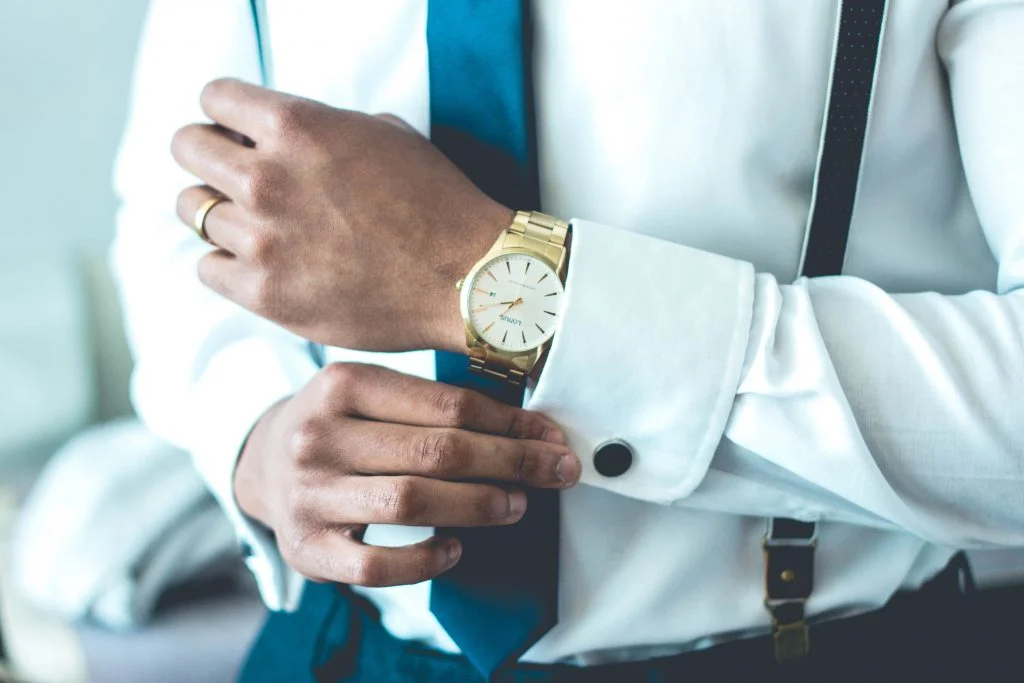 man's arms with gold watch