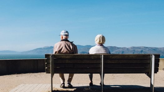 older man and woman on bench