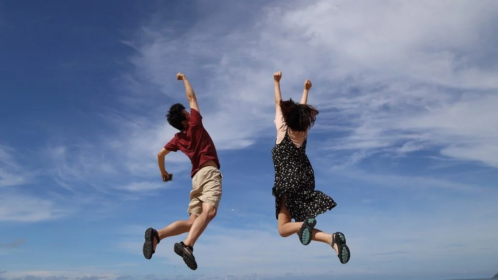 2 people jumping into the air